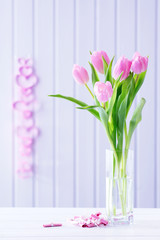 Beautiful pink tulips in vase with decorative hearts