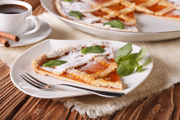 Piece of Italian tart with apricot jam and coffee