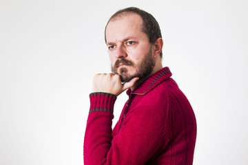 Man in red sweater, with beard and mustaches in skeptic pose
