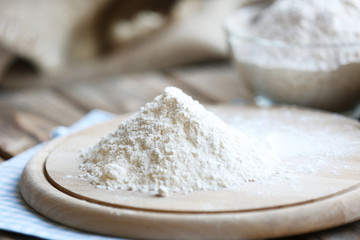 Fototapeta na wymiar Pile of flour on cutting board, closeup