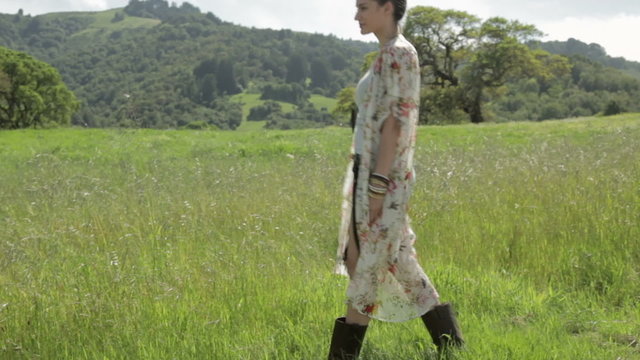 Side view of a young woman walking in nature and looking away