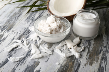Coconut with coconut oil in bowl with jar of cosmetic cream