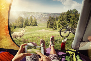 Sport.Tourism. Cyclist in the tent with the mobile