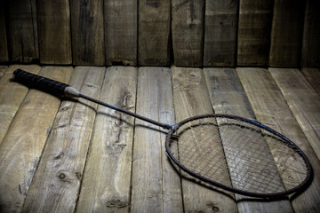 Old badminton racket on wood background