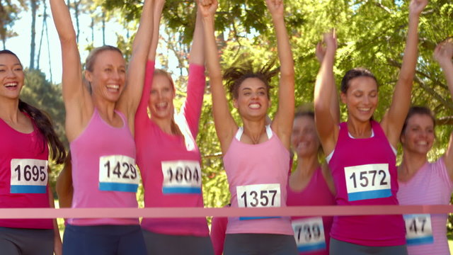 Smiling women running for breast cancer