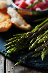 Asparagus with ham on the wooden table, selective focus