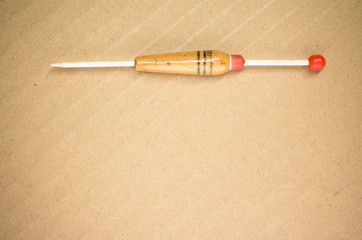 single cork made fishing buoyant on a paperboard background - view from above