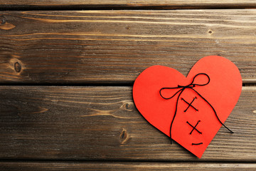 Stitched heart on wooden background