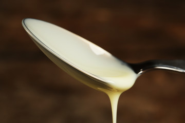 Spoon with condensed milk close up