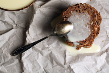 Slices of bread with condensed milk on paper background