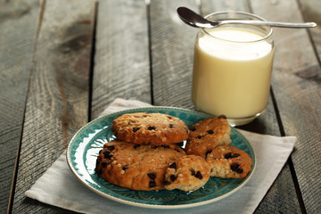 Cookies on plate with jar of condensed milk on wooden