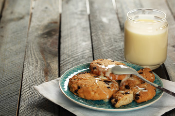Cookies on plate with jar of condensed milk on wooden