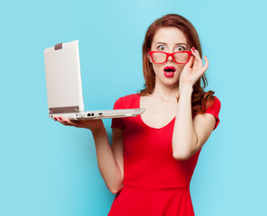 Surprised redhead girl with laptop