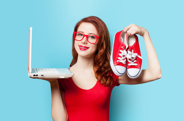 Style redhead girl with gumshoes and laptop
