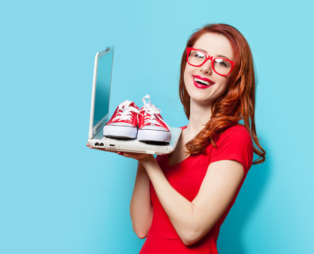 Style redhead girl with gumshoes and laptop