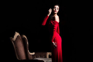 Obraz na płótnie Canvas Sexy woman in red dress in darkness