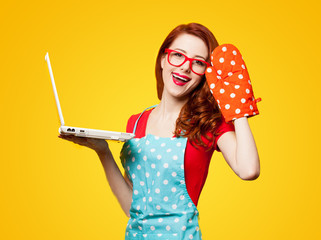 Young housewife with computer and oven gloves