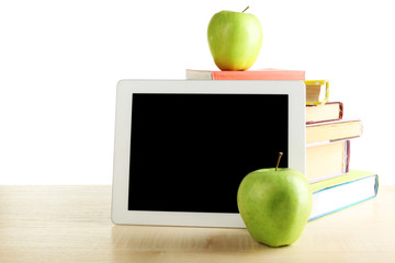 Books, PC tablet and apple on desk, isolated on white