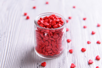 Colorful sprinkles on jar on table close-up