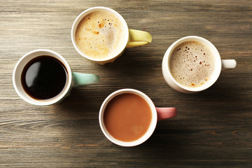 Many cups of coffee on wooden table background