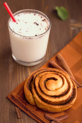 Homemade cinnamon bun with hot milk