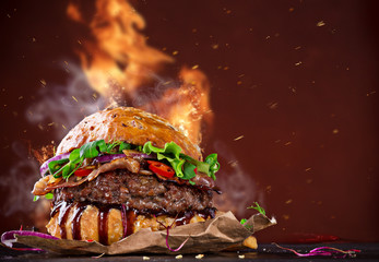 Delicious burger with fire flames - obrazy, fototapety, plakaty