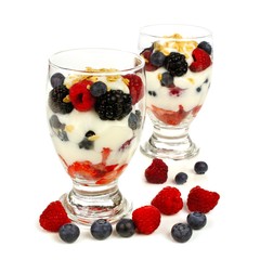 Healthy mixed berry, granola and yogurt parfaits over white