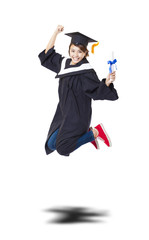 Happy female student in graduate robe jumping against white back