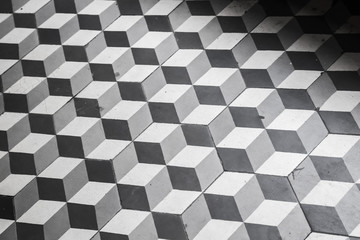 Old black and white tiling on the floor, cubic pattern