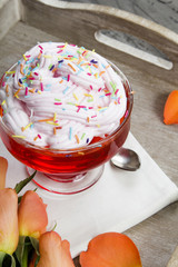 Colorful jelly with whipped cream and candy topping