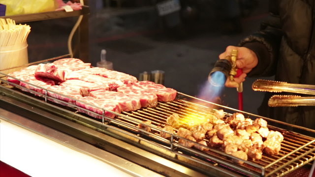 Vendor cooking beef with blowtorch at Taiwan Night Market 