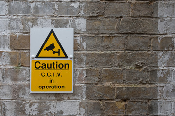 CCTV Caution Sign on Vintage Brick Wall