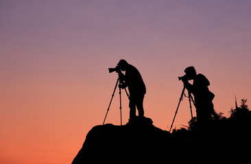 Silhouette of a photographers who shooting a sunset on the mount