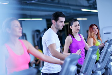 Group of people running on treadmills