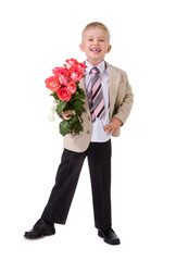 Cute little gentleman standing with big bouquet of red roses
