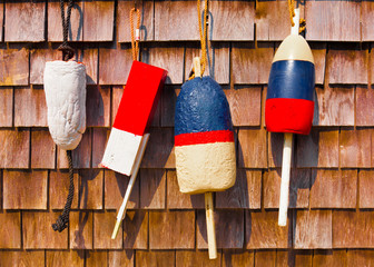 Red white and blue vintage fishing buoys on wood shingles