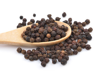 Black pepper in wooden spoon on white background.