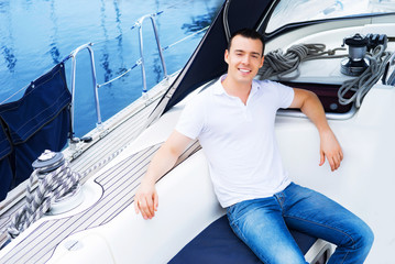A handsome man relaxing on a boat on the sea