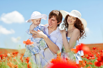 Happy young family in flowers field