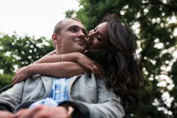 Fototapeta premium Young European couple cuddling on a park bench
