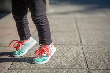 Fototapeta na wymiar Little girl with sneakers and leggins training outdoors