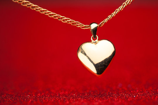 Gold Heart Pendant On Red Background