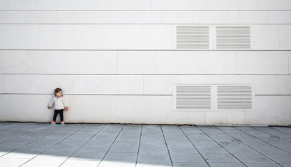 Little girl with sportive look posing over wall