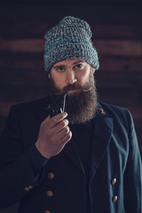 Stylish Man with Long Beard Smoking Using a Pipe