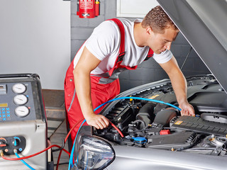 Car mechanics checks the air handling unit of a car