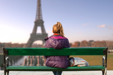 Lonesome girl watching at Paris city scape at sunset/sunrise.