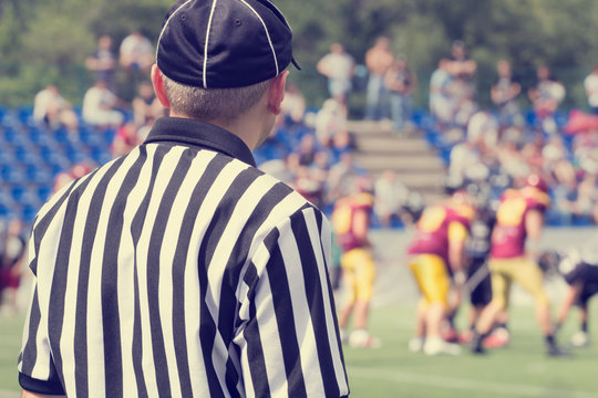 American football referee and de-focused players.