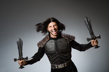 Angry knight with sword against dark background