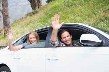 Young couple smiling and waving