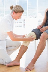 Obraz premium Doctor examining her patient knee